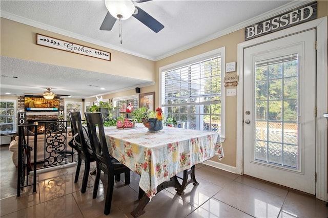 tiled dining room with ceiling fan, a textured ceiling, and ornamental molding