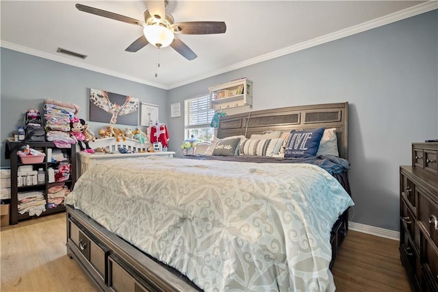 bedroom featuring light hardwood / wood-style floors, ceiling fan, and crown molding