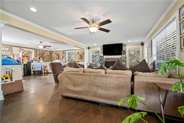 living room with ceiling fan, a fireplace, a textured ceiling, and ornamental molding