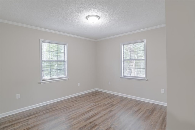 empty room featuring ornamental molding, light hardwood / wood-style floors, and a textured ceiling