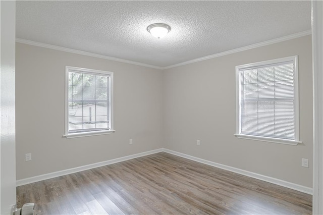 unfurnished room with wood-type flooring, a wealth of natural light, crown molding, and a textured ceiling