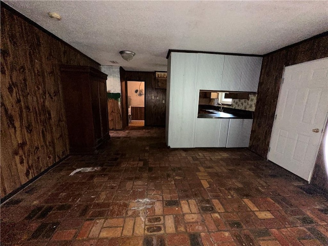 hall with a textured ceiling and wooden walls