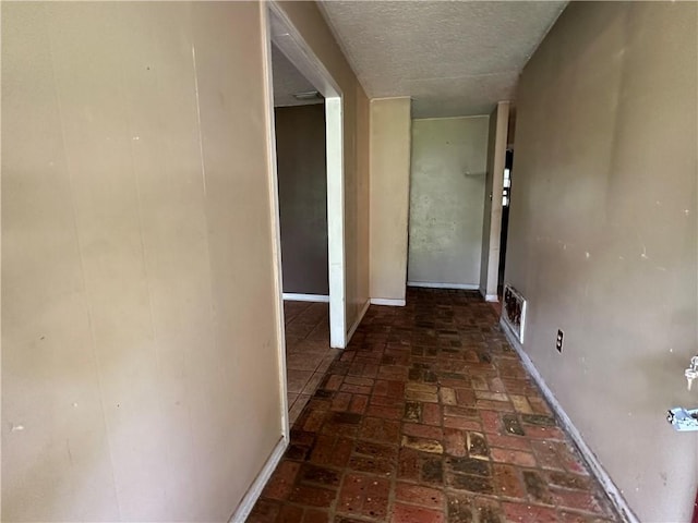 hall featuring a textured ceiling