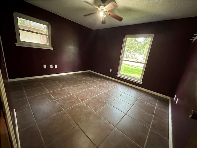 tiled spare room with ceiling fan and a textured ceiling