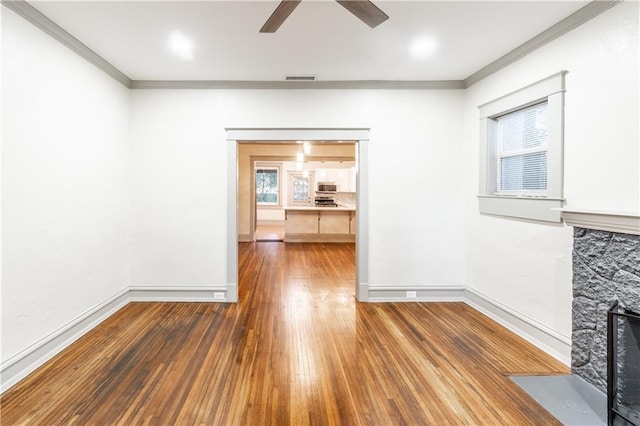 unfurnished living room with plenty of natural light, dark hardwood / wood-style floors, crown molding, and ceiling fan