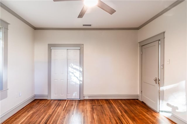 unfurnished bedroom featuring multiple windows, ceiling fan, dark hardwood / wood-style flooring, and ornamental molding