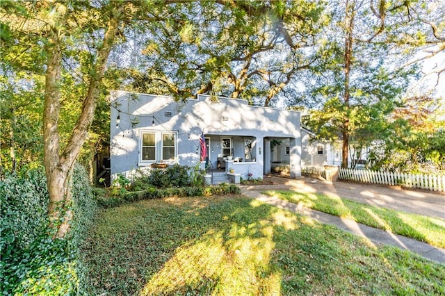 bungalow-style house featuring covered porch and a front yard