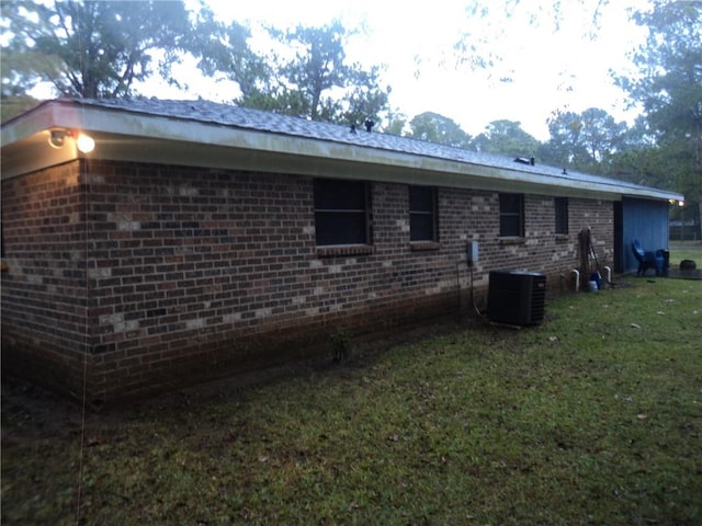 view of home's exterior featuring central AC unit and a yard