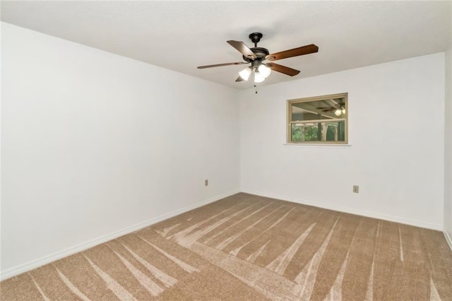 spare room with carpet floors, a ceiling fan, and baseboards