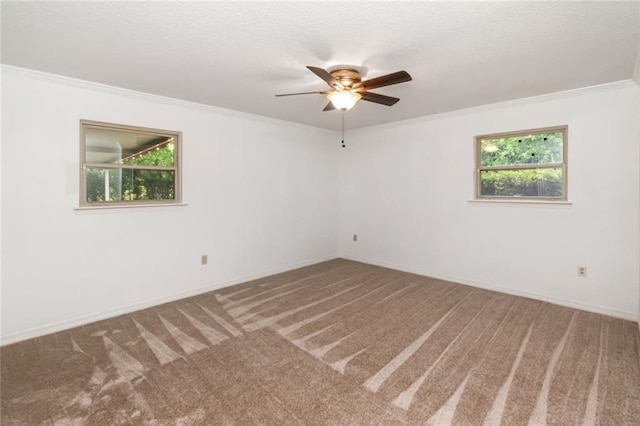 carpeted empty room featuring ornamental molding, ceiling fan, and baseboards