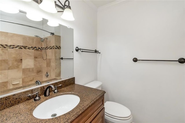 bathroom with toilet, vanity, and crown molding