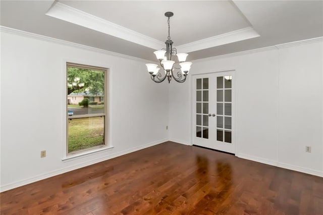 spare room with a chandelier, french doors, a tray ceiling, dark wood finished floors, and crown molding