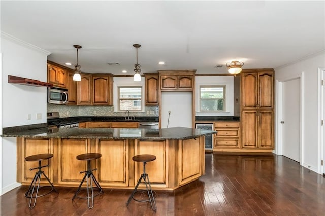 kitchen featuring stainless steel appliances, crown molding, brown cabinets, a peninsula, and decorative backsplash