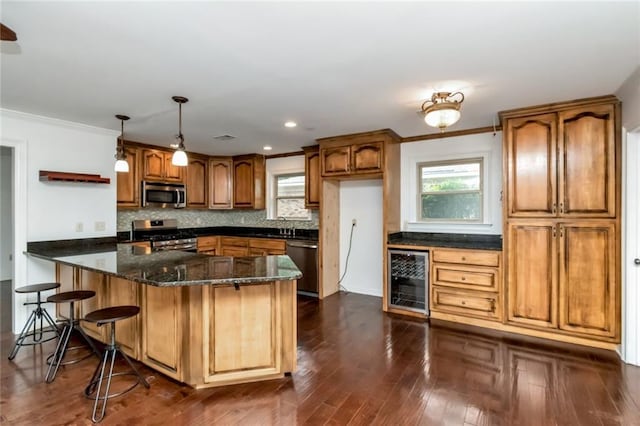 kitchen with appliances with stainless steel finishes, beverage cooler, dark stone countertops, brown cabinetry, and backsplash