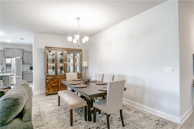 dining area featuring an inviting chandelier, baseboards, and visible vents