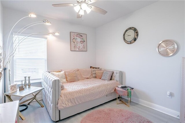 bedroom featuring baseboards, light wood-style flooring, and ceiling fan