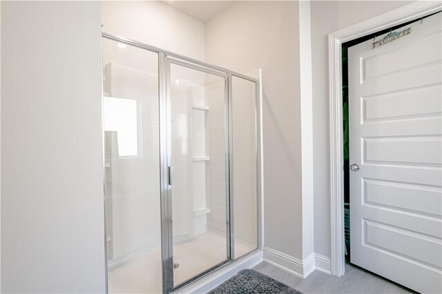 bathroom featuring baseboards and a shower stall