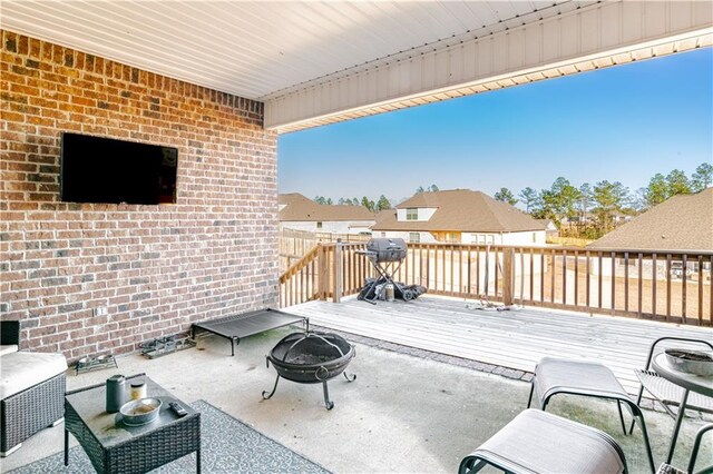 view of patio / terrace featuring a residential view, a fire pit, and a wooden deck