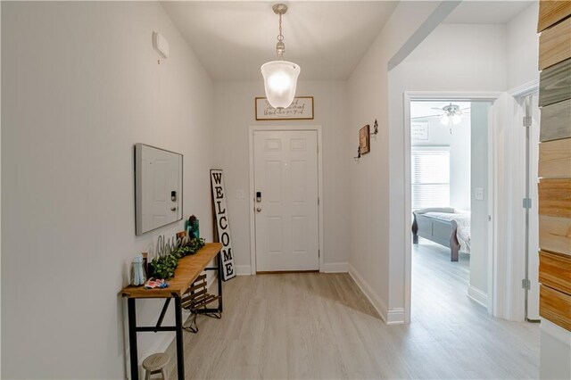 foyer featuring light wood-style floors, baseboards, and ceiling fan