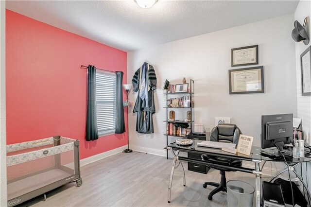 office featuring baseboards and light wood finished floors