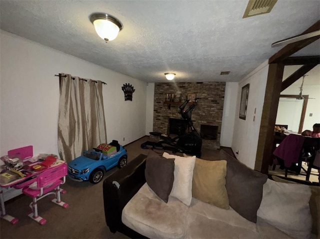 living room with carpet floors, a textured ceiling, and a fireplace