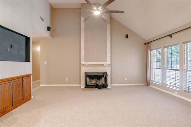 unfurnished living room with ceiling fan, a large fireplace, light colored carpet, and high vaulted ceiling