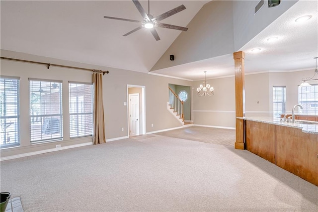 unfurnished living room with sink, high vaulted ceiling, light carpet, ceiling fan with notable chandelier, and ornamental molding