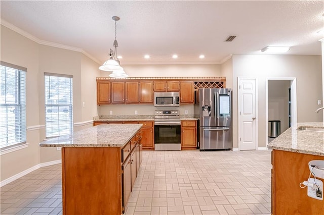 kitchen with light stone counters, sink, stainless steel appliances, and decorative light fixtures