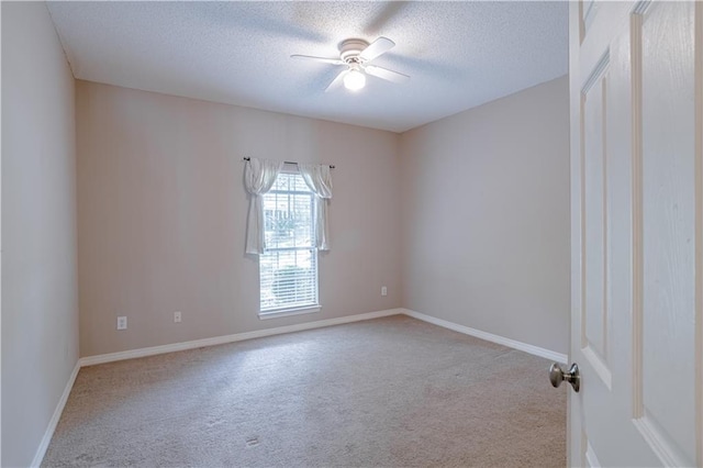 carpeted spare room with ceiling fan and a textured ceiling