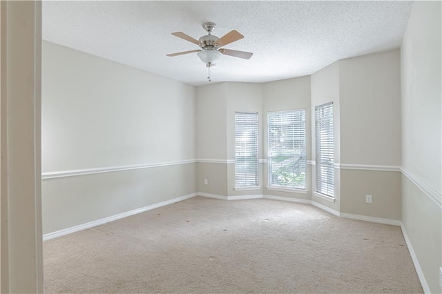 spare room with light carpet, a textured ceiling, and ceiling fan