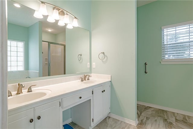 bathroom featuring a shower with door and vanity