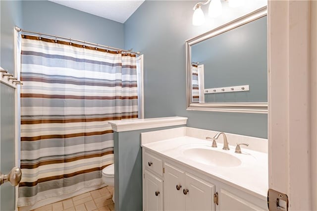 bathroom featuring vanity, toilet, and a textured ceiling