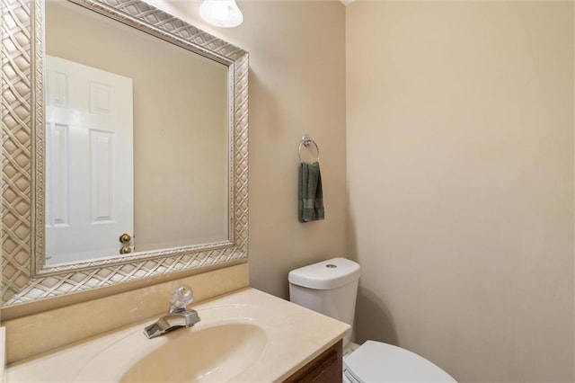 half bath featuring vanity and toilet