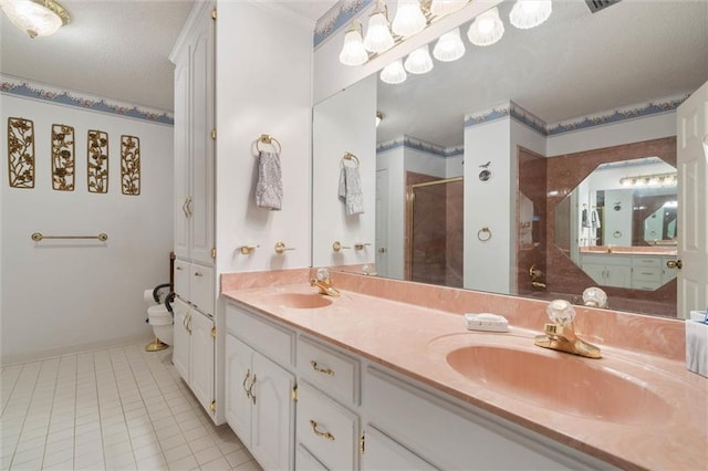full bathroom with double vanity, toilet, a shower stall, and a sink