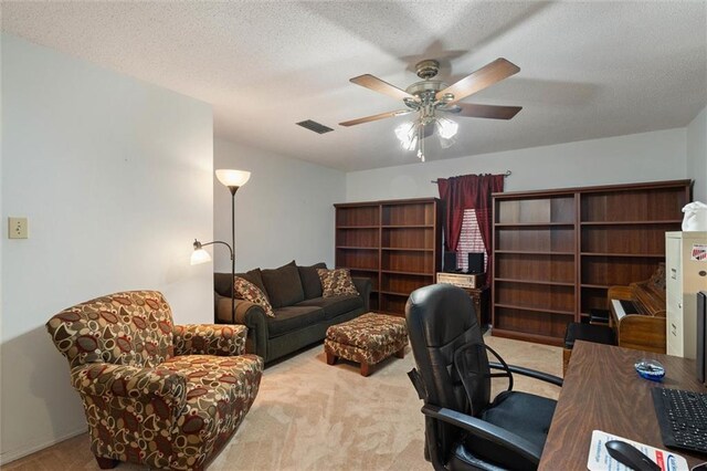 office space with visible vents, carpet flooring, and ceiling fan
