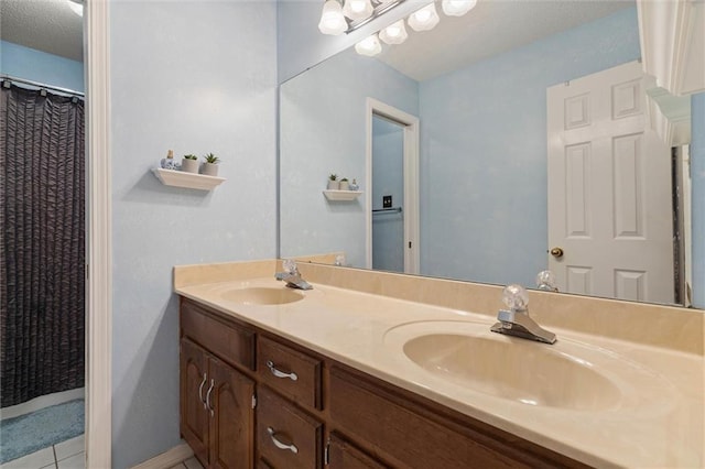 bathroom with double vanity, a sink, and tile patterned floors