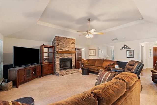 living room with light colored carpet, ceiling fan, a tray ceiling, and a fireplace