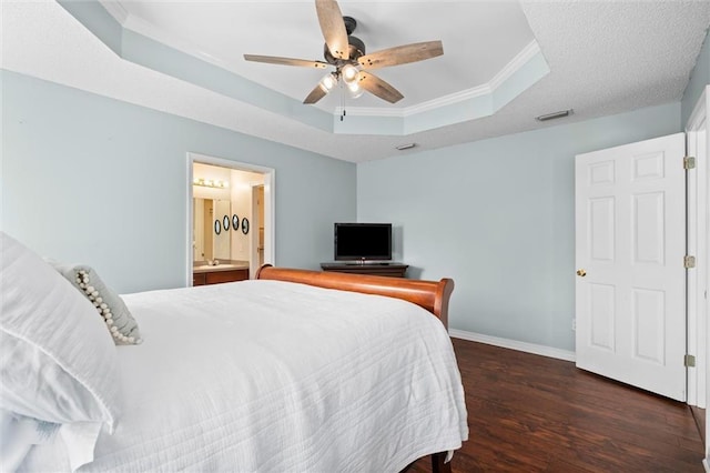 bedroom featuring dark wood-style flooring, visible vents, baseboards, a tray ceiling, and crown molding