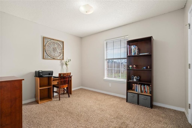 office space with light carpet, a textured ceiling, and baseboards