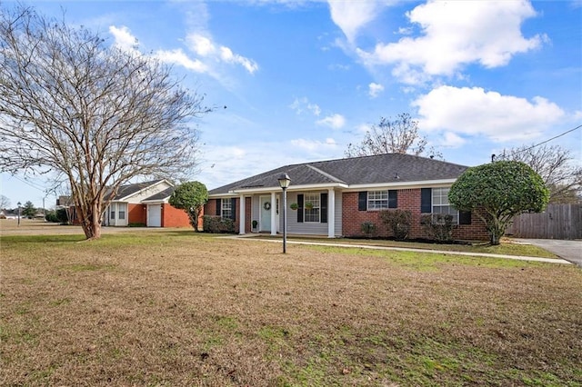 ranch-style house featuring brick siding, fence, and a front yard