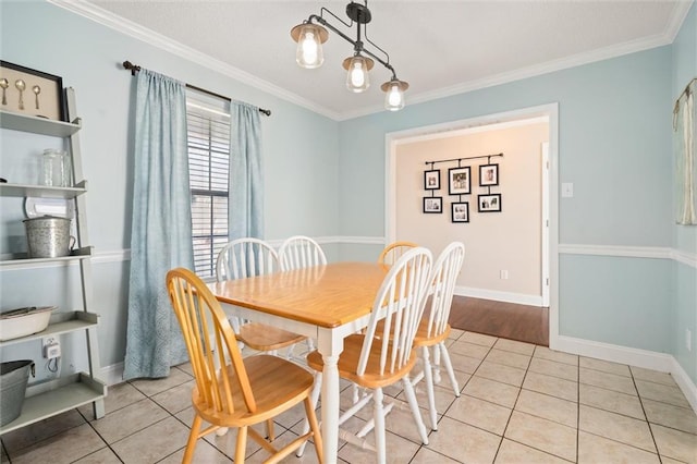 dining room featuring light tile patterned floors, baseboards, and crown molding