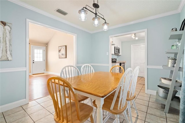 dining area with ornamental molding, light tile patterned flooring, and visible vents