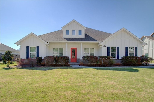 view of front facade with a front yard, board and batten siding, and roof with shingles