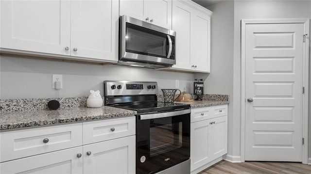 10471 Lowell St W, Mobile, AL 36695 - kitchen with appliances with stainless steel finishes, light wood-style floors, light stone countertops, and white cabinetry