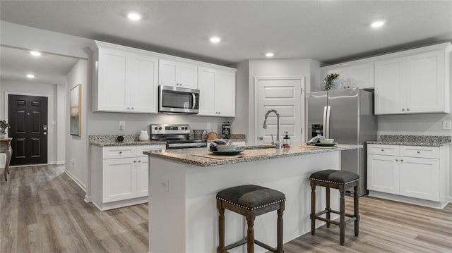 10471 Lowell St W, Mobile, AL 36695 - kitchen featuring appliances with stainless steel finishes, light wood-type flooring, white cabinetry, and recessed lighting