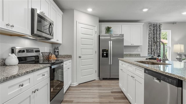 10471 Lowell St W, Mobile, AL 36695 - kitchen with appliances with stainless steel finishes, a sink, light wood finished floors, white cabinets, and recessed lighting