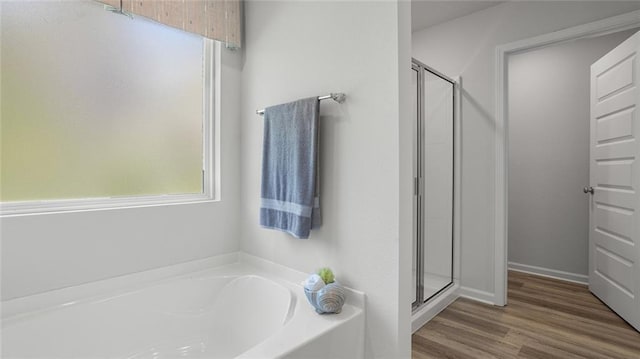 10471 Lowell St W, Mobile, AL 36695 - full bathroom featuring a bath, a shower stall, and wood finished floors