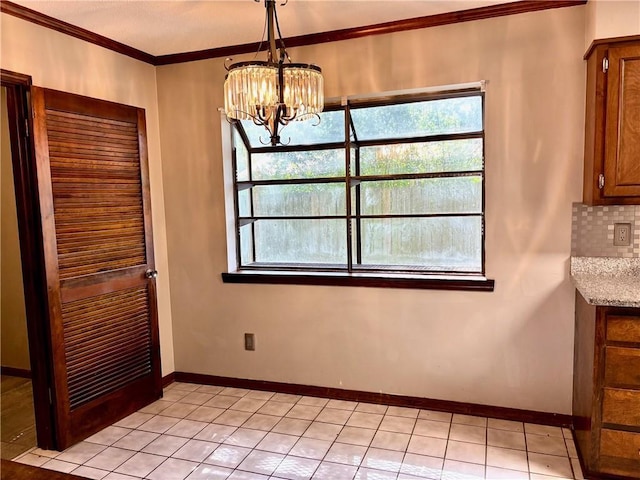 unfurnished dining area with an inviting chandelier, ornamental molding, baseboards, and light tile patterned floors