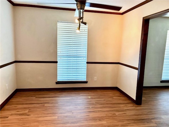 unfurnished dining area featuring baseboards, ceiling fan, ornamental molding, and wood finished floors