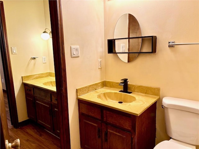 bathroom featuring vanity, wood finished floors, and toilet